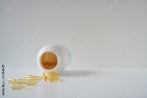 Omega 3 fish oil capsules spilled from a plastic bottle. Medical food supplements. Unsaturated fatty acid. 