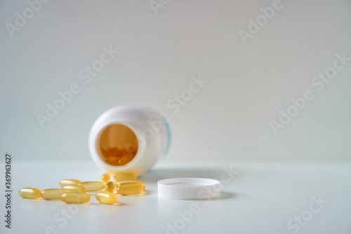 Omega 3 fish oil capsules spilled from a plastic bottle. Medical food supplements. Unsaturated fatty acid. 