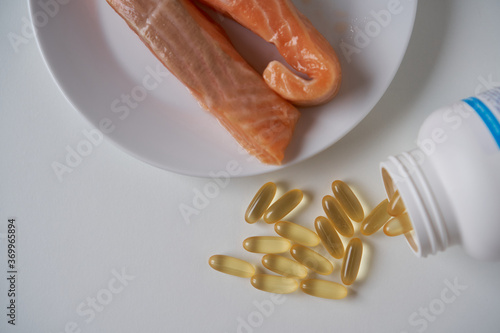 Fish oil capsules and salmon fillet slice                               
