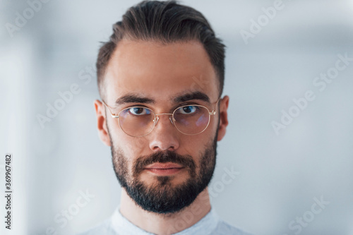 Portrait of young handsome man in formal clothes indoors in the office at daytime