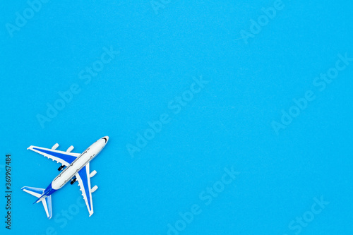 Model air plane on blue sky color background. Flat lay design for travel concept