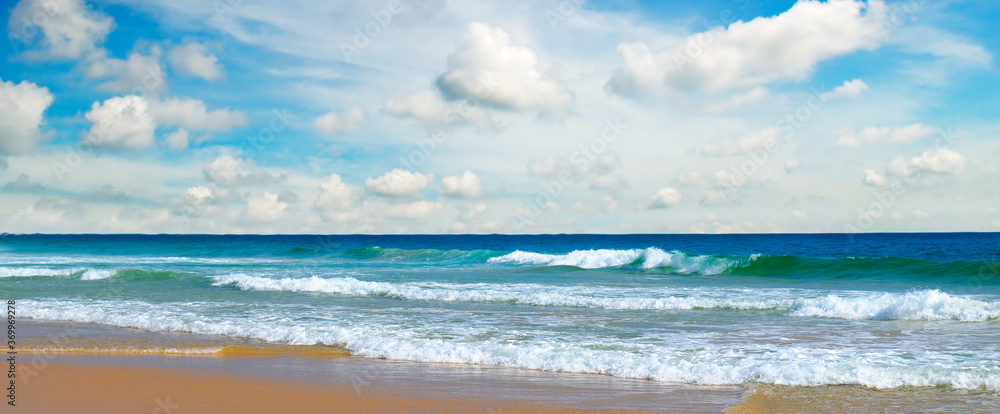 Beautiful beach with turquoise ocean, blue sky with clouds. Wide photo.