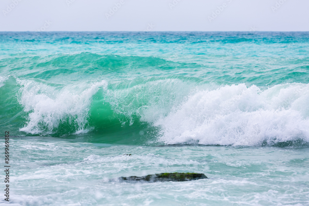 Amazing turquoise waves and white foam. Waves crashing on the coast of Lebanon. Blue sea water. A vibrant seascape for a holiday resort. Lebanese Mediterranean coastline