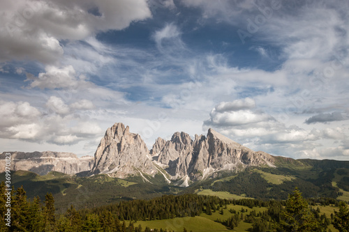 Alpe di Siusi - Seiser Alm with Sassolungo - Langkofel mountain group in front of blue sky with clouds