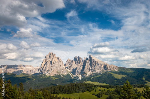Alpe di Siusi - Seiser Alm with Sassolungo - Langkofel mountain group in front of blue sky with clouds