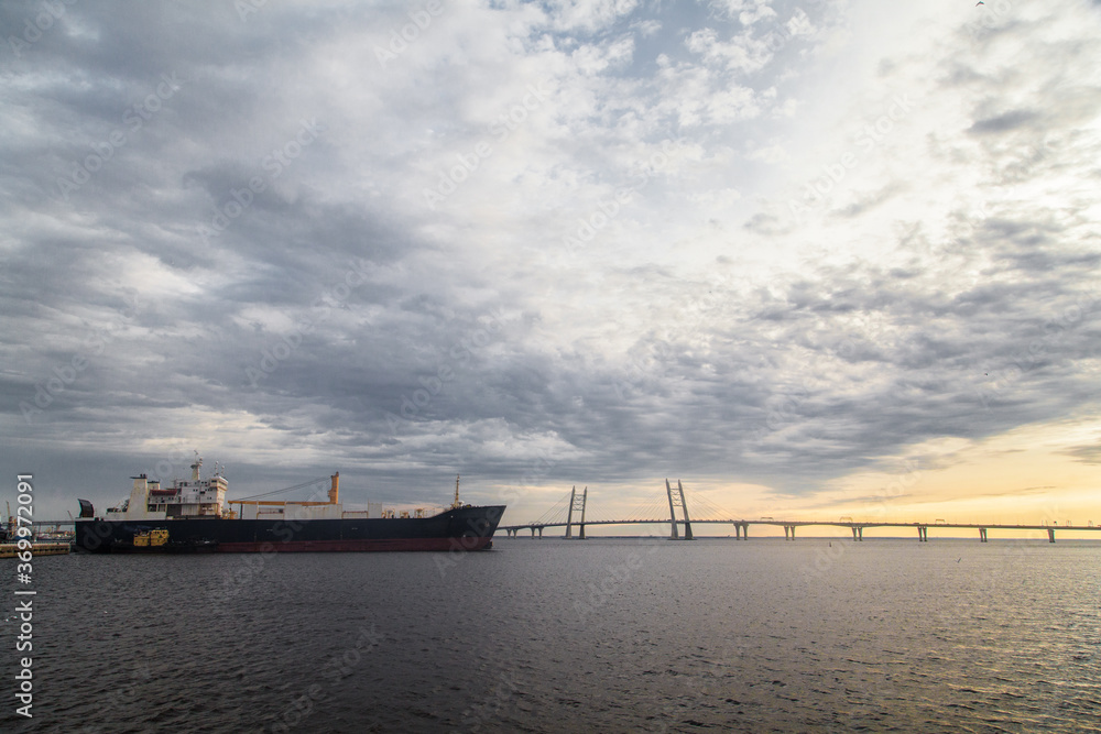 Sunset landscape with cable stayed bridge and big container ship Sunset landscape with cable stayed bridge and big container ship