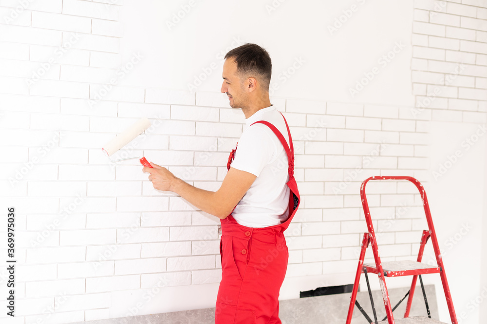 Hands of the master in gloves put glue on a decorative brick before installation on a wall Hands of the master in gloves put glue on a decorative brick before installation on a wall