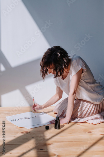 Lovely brunet female practicing calligraphy