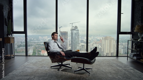 Businessman talking on smartphone in office. Male boss calling on mobile phone © stockbusters