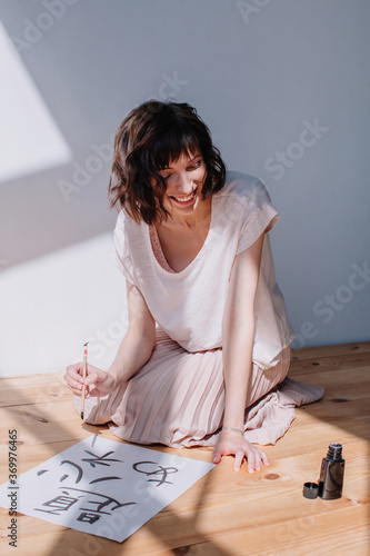 Lovely brunet female practicing calligraphy photo