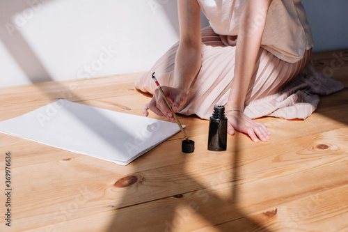 Unrecognizable female creating calligraphy