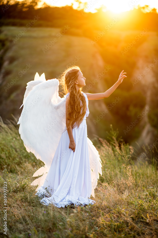 little girl with angel wings. angel and the sun. girl in a white dress. Beautiful girl with long hair in nature at sunset. A girl dressed as an angel.
little girl with angel wings. angel and the sun. girl in a white dress. Beautiful girl with long hair in nature at sunset. A girl dressed as an angel.