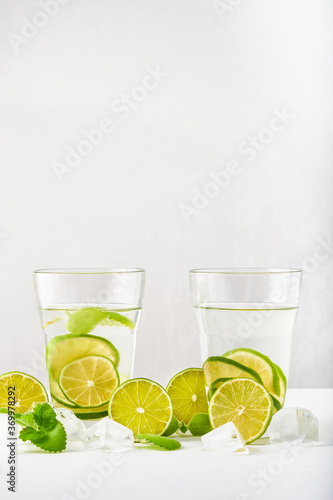 Drink glasses with water ,lime,mint and ice on white background