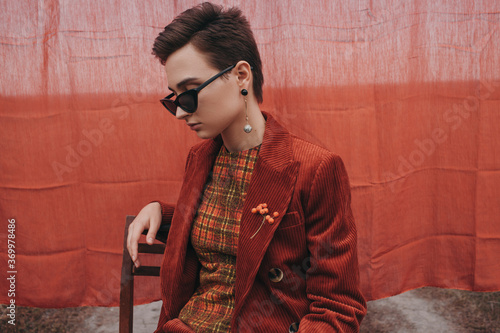 Trendy woman in vintage sunglasses and jacket