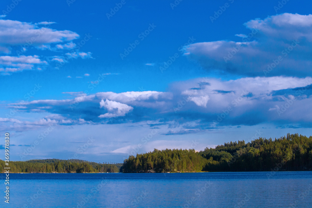 Lake summer view with reflection of clouds on water, Finland