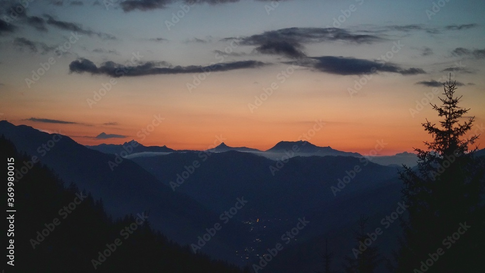 beautiful sunset on the mountains with orange sky and view to the alps