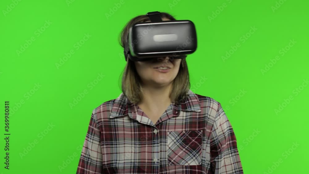 Girl using VR app helmet to play simulation scary game. Woman watching virtual reality 3D video Girl using VR app helmet to play simulation scary game. Woman watching virtual reality 3D video