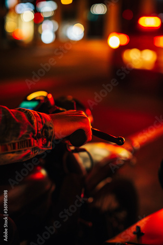 Closeup of Man's Hand Riding Motorcycle in Reddish Night Light