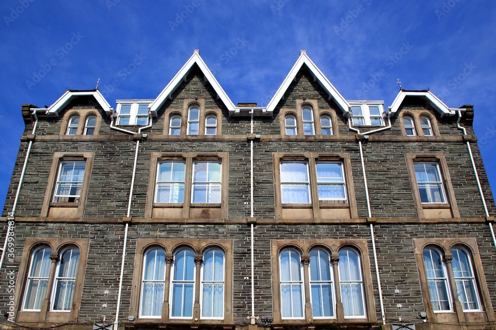 Fototapeta premium Imposing classic stone built building with traditional sash windows and stone mullions