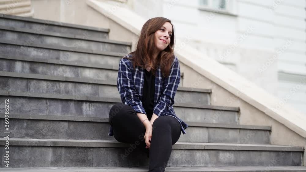 Young woman plays with hair, sitting on steps of mansion. Pretty female letting her hair down, posing on camera. Timelapse. Young woman plays with hair, sitting on steps of mansion. Pretty female letting her hair down, posing on camera. Timelapse.