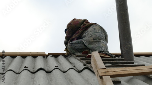 Wallpaper Mural a male construction worker works on the roof Torontodigital.ca