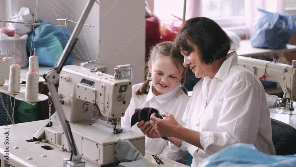 Grandmother with granddaughter at the factory. Family with a fabric. Grandmother with granddaughter at the factory. Family with a fabric.