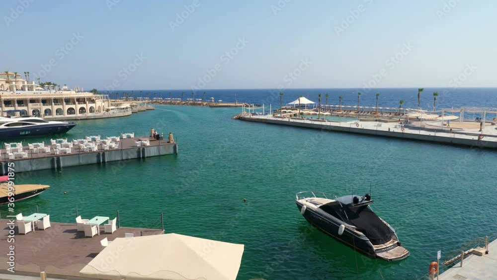 gorgeous sea view from the terrace of an expensive hotel. a yacht marina and a promenade with many coffee tables for visitors. gorgeous sea view from the terrace of an expensive hotel. a yacht marina and a promenade with many coffee tables for visitors.