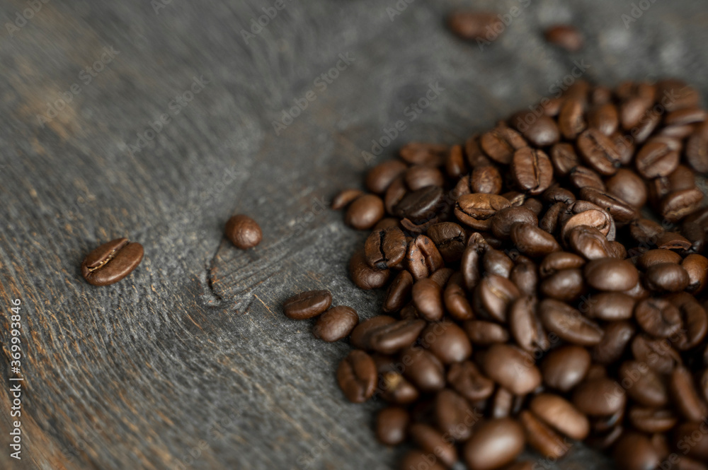 Roasted arabica coffee beans scattered on a wooden table. Fresh coffee beans. Roasted arabica coffee beans scattered on a wooden table. Fresh coffee beans.