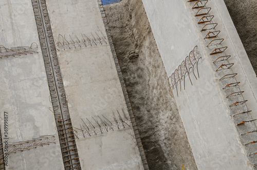 Close-up view of a huge construction surrounding wall or tilt-up panel Angled view of a construction frame made of reinforced precast concrete and steel rods 