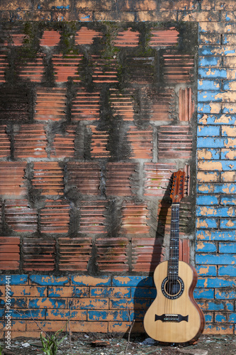 A guitar standing in the old brick wall