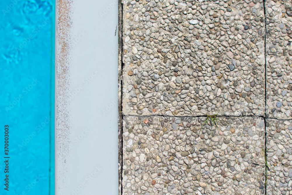 Top view of different materials as a texture. Blue pool, white concrete surround, gray stone slabs. Off to the cool water! Top view of different materials as a texture. Blue pool, white concrete surround, gray stone slabs. Off to the cool water!