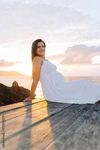 Portrait of a pregnant woman against an oceanic landscape