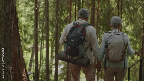 Wallpaper Mural Rear view of old Asian woman and her husband wearing comfortable sportswear and backpacks going down wooden stairs in park and having chat Torontodigital.ca