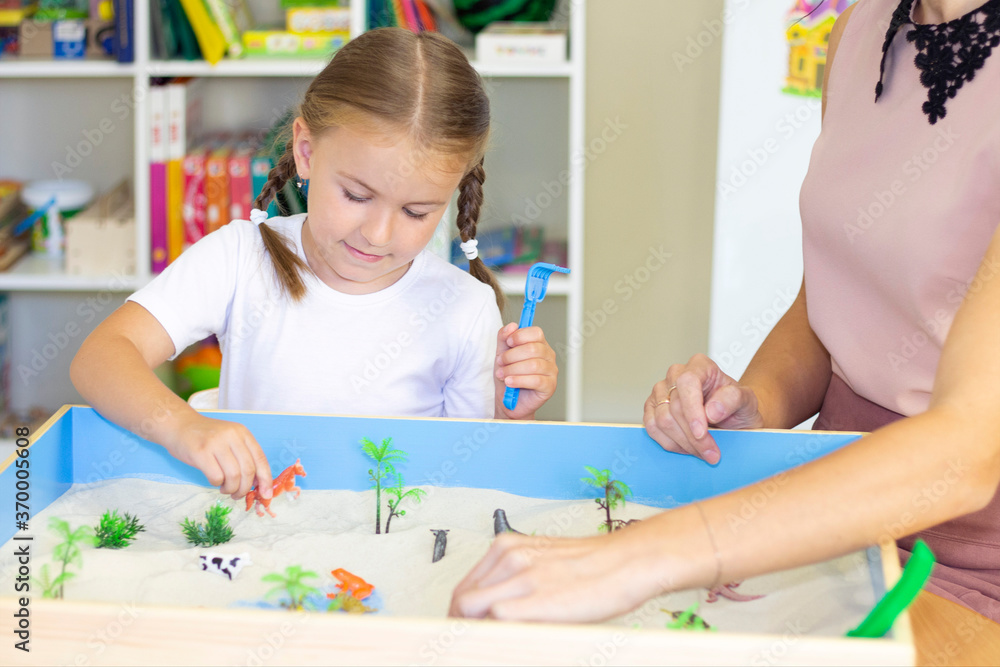 Fototapeta premium girl playing in the sand, educational activity with a child