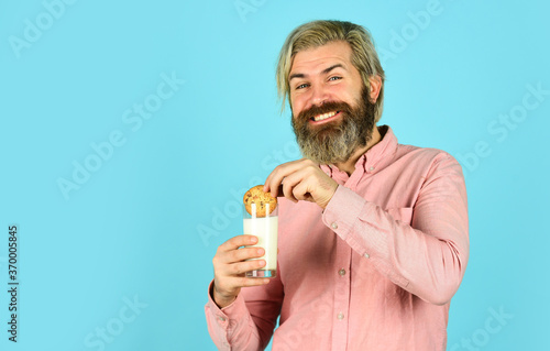 Taste of childhood. Bearded man drink milk with cookies. Yummy combination. Happy hipster eat cookie dessert. Breakfast or lunch. Milk and sweet cookies. Delicious treats. Recipe homemade cookies