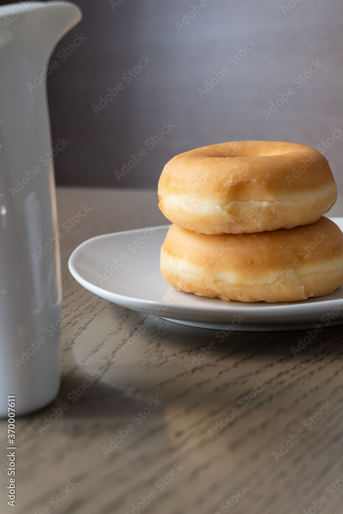 Two fresh donuts for breakfast on a wooden table, espresso cup