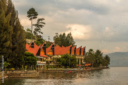 Tableau sur toile A row of Bataknese houses and villas on the shore of Lake Toba