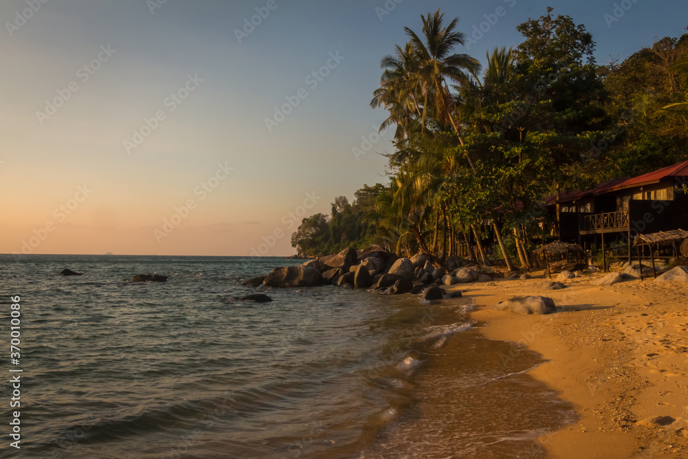 The sun shining on Melina Beach at sunset, Tiomen Island, Malaysia The sun shining on Melina Beach at sunset, Tiomen Island, Malaysia