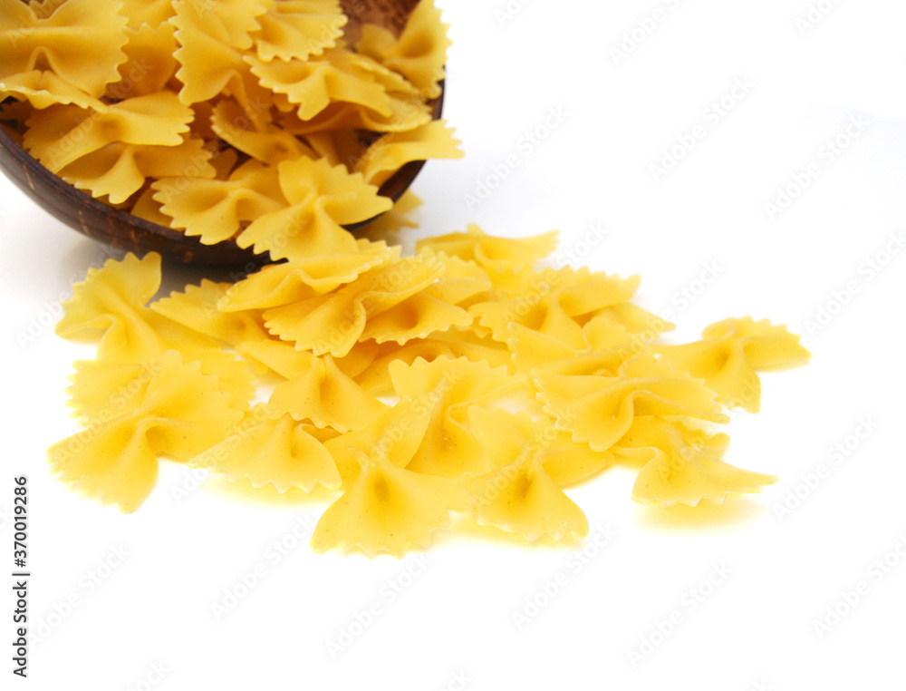 Close up of the background farfalle in wooden bowl on white background Close up of the background farfalle in wooden bowl on white background