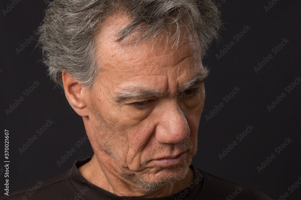Distraught unshaven senior man at home looking depressed and tired of being locked down Distraught unshaven senior man at home looking depressed and tired of being locked down