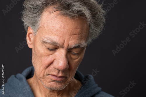  Distraught unshaven senior man at home looking depressed and tired of being locked down