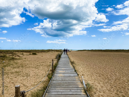 Wooden boardwalk leading across the beach to the sea at Great Yarmouth under a blue sky with clouds, Norfolk