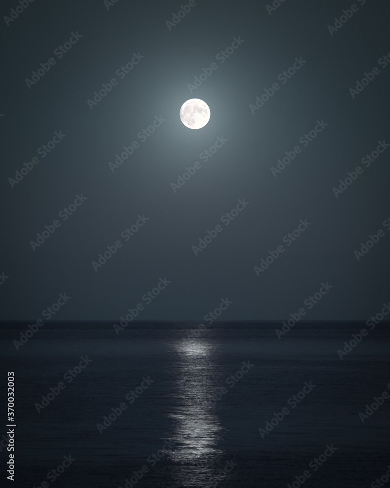 A dark moody sea with lonely glowing moon in Crimean peninsula at night A dark moody sea with lonely glowing moon in Crimean peninsula at night