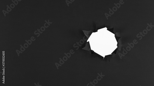 black abstract paper background with black torn hole