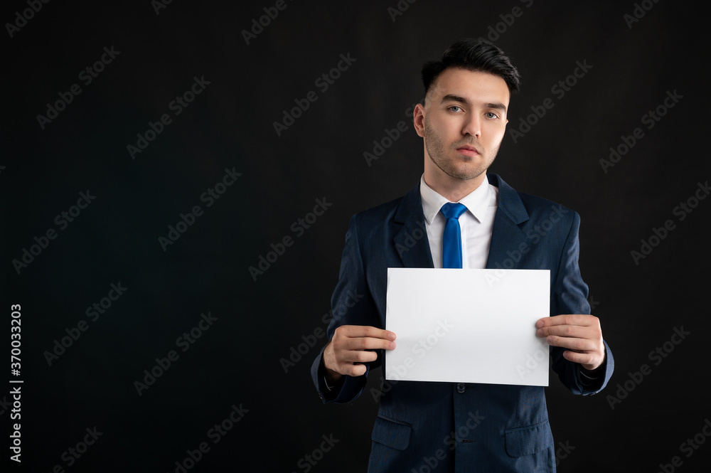 Portrait of sad business man wearing blue business suit and tie holding white paper Portrait of sad business man wearing blue business suit and tie holding white paper