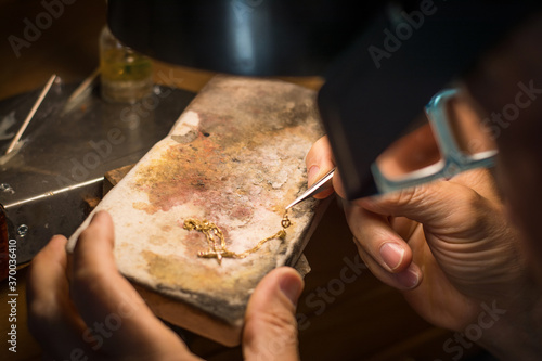 Hands of a craftsman jeweler working on jewelry. Goldsmith. Goldsmith workshop jewels and articles of work value
