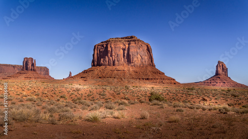 The towering red sandstone formations of West Mitten Butte, Merrick Butte, East Mitten Buttes in Monument Valley Navajo Tribal Park desert landscape on the border of Arizona and Utah, United States
