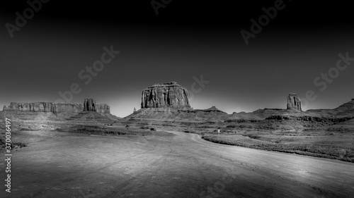 Black and White Photo of The sandstone formations of West Mitten Butte, Merrick Butte and Cly Butte in the desert landscape of Monument Valley Navajo Tribal Park in southern Utah, United States