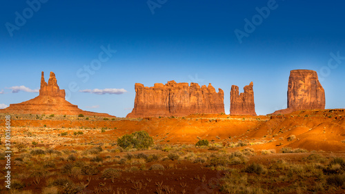 The sandstone formations of Mitten Buttes and Cly Butte in the desert landscape of Monument Valley Navajo Tribal Park in southern Utah, United States