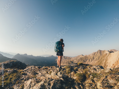 Chica con mochila delante de montañas